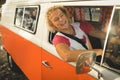 Smiling young man sitting in camper van