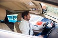 Smiling young man driving his car through city traffic Royalty Free Stock Photo