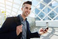 Smiling young man with smart phone and bag Royalty Free Stock Photo