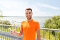 Smiling young man with smartphone and earphones Royalty Free Stock Photo