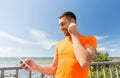 Smiling young man with smartphone and earphones Royalty Free Stock Photo