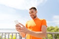 Smiling young man with smartphone and earphones Royalty Free Stock Photo