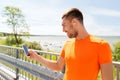 Smiling young man with smartphone and earphones Royalty Free Stock Photo