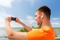 Smiling young man with smartphone and earphones Royalty Free Stock Photo