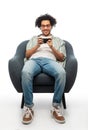 smiling young man with smartphone sitting in chair Royalty Free Stock Photo