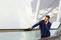 Smiling young man standing on escalator talking on cell phone Royalty Free Stock Photo