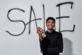 Smiling young man standing near graffiti on white wall Royalty Free Stock Photo