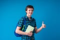 Smiling young man student in casual clothes with a backpack holding books Royalty Free Stock Photo