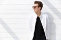 Smiling young man in sunglasses over white wall background Royalty Free Stock Photo