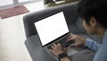 Smiling young man surfing internet with computer laptop while lying on sofa at home. Royalty Free Stock Photo