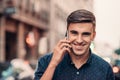 Smiling young man talking on his cellphone in the city Royalty Free Stock Photo