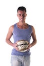 Smiling young man in tanktop holding soccer ball