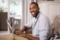 Smiling young man using laptop at home Royalty Free Stock Photo