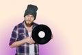 Smiling young man with vinil isolated on colorful background