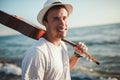 Young man walking on the beach holding a guitar in his hands Royalty Free Stock Photo