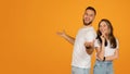 Smiling young man and woman in casual white t-shirts and blue jeans posing playfully Royalty Free Stock Photo