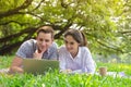 smiling young man and woman couple using computer to searching for information for weddings, honeymoon travel, insurance and home