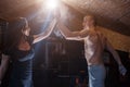 Smiling young man and woman doing high five in gym. Couple wearing sportswear Royalty Free Stock Photo