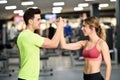 Smiling young man and woman doing high five in gym Royalty Free Stock Photo