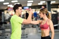 Smiling young man and woman doing high five in gym Royalty Free Stock Photo