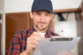 Smiling young man writing on clipboard Royalty Free Stock Photo