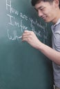 Smiling young man writing English sentences on the blackboard Royalty Free Stock Photo