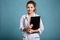 Smiling young medical nurse in uniform holding clipboard Royalty Free Stock Photo