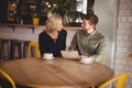 Smiling young man and woman sitting with coffee cups at cafe Royalty Free Stock Photo