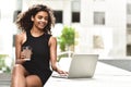 Smiling young mixed race woman using her laptop to chat online Royalty Free Stock Photo