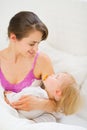 Smiling young mother holding sleeping baby Royalty Free Stock Photo