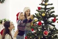 Happy mom and kids decorate Christmas tree at home Royalty Free Stock Photo