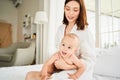 Smiling young mother taking care of newborn baby son after shower Royalty Free Stock Photo