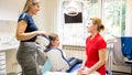 Smiling young mother talking to pediatric dentist in dentist office Royalty Free Stock Photo