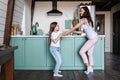 Smiling young mother teaching adorable kid to dance in modern kitchen Royalty Free Stock Photo