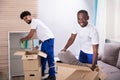 Movers Unpacking The Cardboard Boxes In The Home Royalty Free Stock Photo