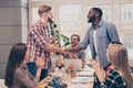 Smiling young multiethnic businessmen shaking hands in office on meeting Royalty Free Stock Photo