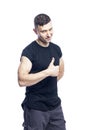 Smiling young muscular man in a black t-shirt shows like. Activity, energy and sport. Space for text. Isolated on white background Royalty Free Stock Photo