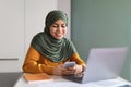 Smiling Young Muslim Woman In Hijab Using Smartphone In Office Royalty Free Stock Photo