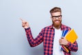 Smiling young nerdy red bearded stylish student is standing with Royalty Free Stock Photo