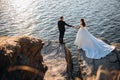 Smiling young newly married wedding couple on walk in rocky cliff Royalty Free Stock Photo