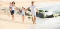 parents with two kids jogging on beach . Royalty Free Stock Photo