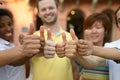 Smiling young people giving thumbs up sign Royalty Free Stock Photo