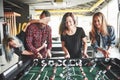 Smiling young people playing table football while indoors Royalty Free Stock Photo