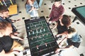 Smiling young people playing table football while indoors Royalty Free Stock Photo