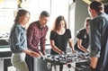 Smiling young people playing table football while indoors Royalty Free Stock Photo