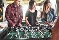 Smiling young people playing table football while indoors Royalty Free Stock Photo