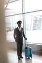 smiling young pilot in professional uniform with suitcase Royalty Free Stock Photo