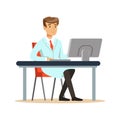 Smiling young professor of computer science sitting behind desk