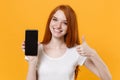 Smiling young redhead woman girl in white t-shirt posing isolated on yellow wall background. People lifestyle concept Royalty Free Stock Photo