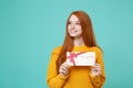 Smiling young redhead woman girl in yellow knitted sweater posing isolated on blue turquoise background in studio Royalty Free Stock Photo